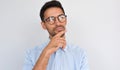 Horizontal image of pleased pensive male keeps hand under chin, looking aside, on white studio background. Successful unshaven man Royalty Free Stock Photo