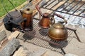 Horizontal image of several cast iron and copper kettles on open fire pit Royalty Free Stock Photo