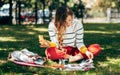 Horizontal image of a student female sitting on the green grass at the college campus on a sunny day, have lunch and studying. The Royalty Free Stock Photo