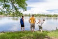 Three guys standing by the water in the park spending quality ti Royalty Free Stock Photo