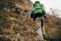 Image of traveler bearded man trekking and mountaineering during his journey. Rear view of young male hiking in mountains. Royalty Free Stock Photo