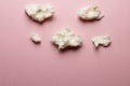 Horizontal image of tufts of homemade white candy floss, on pink background with copy space