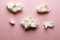Horizontal image of tufts of homemade white candy floss, on pink background