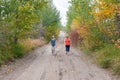 Two caucasian women walking down a rural road.