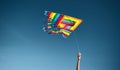 Horizontal image of a woman`s hand taking a colorful flying kite against the blue sky. Freedom concept Royalty Free Stock Photo