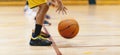 Horizontal image of young basketball player bouncing ball in training drill. Youth basketball team on training