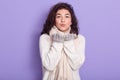 Horizontal indoor shot of emotional charming ÃÂute brunette standing isolated over lilac background in studio, wearing white