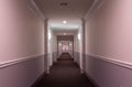 Horizontal interior view of the hallway of a modern apartment building; with sconces, doorways, molding, lighting  and carpeting Royalty Free Stock Photo