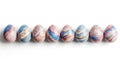 A Row of Eight Marbled Easter Eggs with Blue Pink and Gold Swirls on a White Background painted Royalty Free Stock Photo