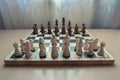 Retro style wooden material chessboard with chess pieces set ready for strategic mind game. Royalty Free Stock Photo