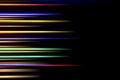 Horizontal multicolor light rays on a black background. Long exposure photo