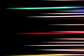 Horizontal multicolor light rays on a black background. Long exposure photo