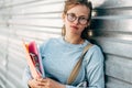 Horizontal outdoor image of a pretty female student carrying lots of books after a day in the college. Beautiful young woman Royalty Free Stock Photo