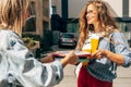 Horizontal outdoor image of two students sharing the books to teach others on the college campus. University young females college Royalty Free Stock Photo