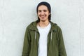 Horizontal outdoor portrait of cheerful attractive youngster, smiling, being in good mood, standing straight isolated over white