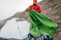 Horizontal outdoors image of authentic young hiker man prepares his tent in mountains. Royalty Free Stock Photo