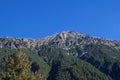 Horizontal panorama of a beautiful majestic mountain on a sunny afternoon and a deep blue sky.