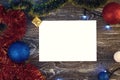 Horizontal paper blank with christmas lights frame. Flat lay. New year card gift. Gold presents, green and red tinsel, balls, Royalty Free Stock Photo