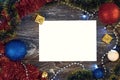 Horizontal paper blank with christmas lights frame. Flat lay. New year card gift. Gold presents, green and red tinsel, balls, Royalty Free Stock Photo