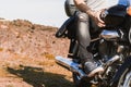 Horizontal partial view of young biker riding a custom motorcycle