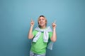 horizontal photo of a blond positive bright girl in a casual outfit on a blue background with copy space