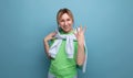 horizontal photo of a blond positive bright girl in a casual outfit on a blue background with copy space