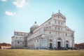 Horizontal photo with famous Piazza del Duomo cathedral. Building is placed on Piazza dei Miracoli with leaning tower. Grass is