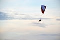 Horizontal photo of the flight of two people on a paraglider in a clear slightly cloudy sky in the summer