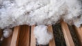 Fuzzy and white pure sheep wool laying down in wooden planks surface with stray visible underneath. Royalty Free Stock Photo