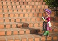 Chiang Mai, Thailand - November 2017: Hmong girl in traditional dress at bottom of Naga stairs to Doi Suthep temple.