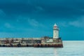 Horizontal photo of a lighthouse with a red lantern on the background of the sea Royalty Free Stock Photo