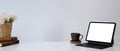 Horizontal photo of minimal workplace with computer tablet, plant, book and coffee cup on white table. Royalty Free Stock Photo