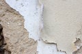 Old and damaged adobe wall with several layers of paint peeling off. Rustic background or texture with copy space.