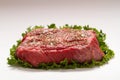 Seasoned Raw Beef On Green Leaf Lettuce on White Background