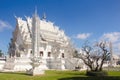 Side view from the garden to Wat Rong Khun or White Temple`s Ubosot in a sunny day. Chiang Rai Province, Thailand.