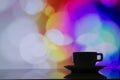 Horizontal photo of silhouette coffee cup on colorful bokeh back