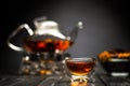 Horizontal photo of the tea set on a black background. Glass transparent teapot and cup. Black leaf tea. Royalty Free Stock Photo