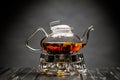 Horizontal photo of the tea set on a black background. Glass transparent teapot and cup. Black leaf tea. Royalty Free Stock Photo