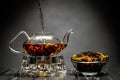 Horizontal photo of the tea set on a black background. Glass transparent teapot and cup. Black leaf tea. Royalty Free Stock Photo