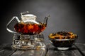 Horizontal photo of the tea set on a black background. Glass transparent teapot and cup. Black leaf tea. Royalty Free Stock Photo