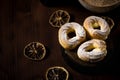 Three cream puffs on dark board with cinnamon sugar and orange rings Royalty Free Stock Photo