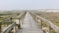 Wooden footbridge of Costa Nova beach in a foggy morning. Aveiro, Portugal Royalty Free Stock Photo