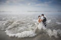 Bride and Groom Wedding Cake Topper Wearing Surgical Masks in the Waves of the Ocean Royalty Free Stock Photo