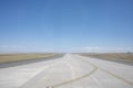 Empty Airport Runway on a Sunny Day with Blue Sky and Clouds Royalty Free Stock Photo