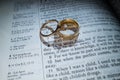Gold Wedding Rings on a Bible with the Scripture Love Never Fails Royalty Free Stock Photo