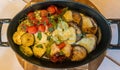 Horizontal picture of an assortment of baked vegetables with provolone cheese melted on top.