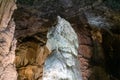 Horizontal picture of a giant white stalagmite inside Postojna cave.