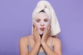 Horizontal picture of good looking magnetic female putting hands on face, having face mask, caring about skin, doing beauty