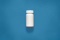 Horizontal picture of plastic white container, mini bottle for pills, being located in middle of whole composition, situated over Royalty Free Stock Photo