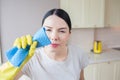 Horizontal portrain of woman stands and cleans lenz of camera. She is very concentrated on that. Girl is cleaning it